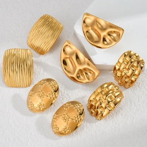 Minimalist gold oval and geometric textured stainless steel earrings on white pedestal