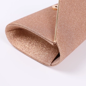 Detail of glitter champagne gold evening bag featuring golden metal frame and clasp closure