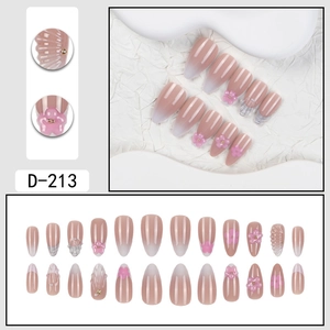 Detail of almond-shaped press-on nails with 3D pink flowers and pearl accents