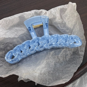 Detailed view of light blue chain-link hair claw clip with golden metal spring