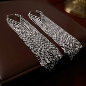 Detailed view of silver cascading chain fringe earrings with geometric triangle top