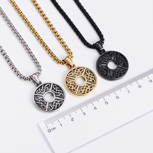 Macro detail of round Celtic knot pendants in silver, gold, and black with size ruler