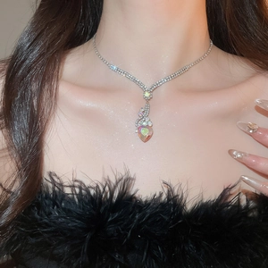 Close-up of elegant silver necklace with heart crystal pendant on a model's neck