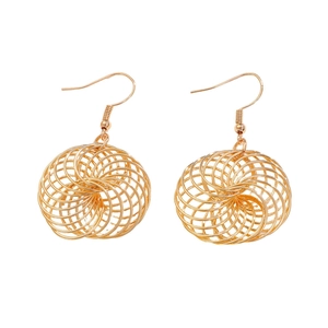 Close-up of golden hollow spiral ball pendant earrings with polished metallic finish