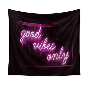 Detail of black tapestry fabric showing neon 'good vibes only' lettering and soft texture