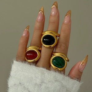 Detailed view of three vintage gold rings with malachite, onyx, and red carnelian stones