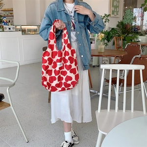 Detail view of corduroy heart pattern tote bag with woven Love label in a cafe setting
