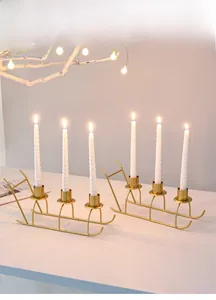 Detailed close-up of two golden sleigh metal candle holders for festive table decoration