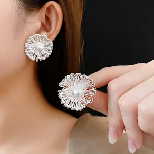 Creative silver petal earrings with center pearl detail shown on model and in close-up
