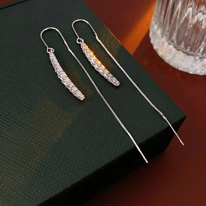 Orecchini lunghi in argento con zirconi scintillanti su una custodia in pelle verde