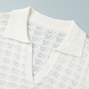 Detail of white crochet knit top featuring a hollow-out geometric pattern and polo collar
