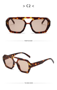 Detail view of tortoiseshell geometric sunglasses with double bridge and light brown lenses