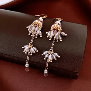 Ethnic glass beaded tassel earrings with gold-tone hooks and pink teardrop pendants