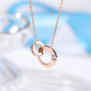 Detailed macro view of 18k rose gold interlocking circles pendant with small diamonds