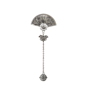 Close-up of vintage silver folding fan brooch with hollow metal ball and bow details