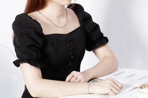 Close-up of minimalist silver paperclip chain necklace and bracelet on model