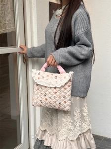 Detailed view of pink quilted laptop bag with cute bear patterns and lace trim