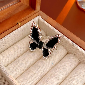 Macro shot of silver butterfly ring with black inlay and gemstone in a jewelry box