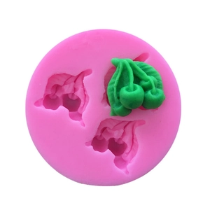 Pink silicone mold featuring dual cherry cavities with a finished green cherry sample