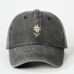 Close-up of small daisy embroidery and vintage washed cotton texture on baseball cap