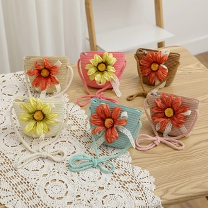 Détail de mini sacs bandoulière en paille pour enfants avec marguerites et nœud dentelle