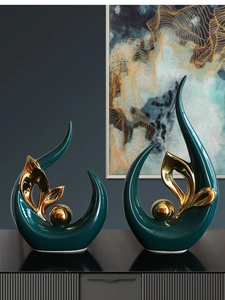 Detailed close-up of modern abstract ceramic statues in teal and electroplated gold