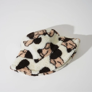 Detail of plush lamb wool bucket hat with cute pink and brown cartoon bear patterns