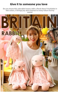Detailed view of three pink plush rabbits with floral dresses and long floppy ears