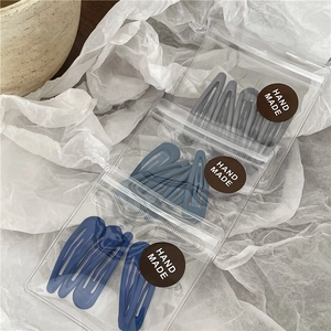Detail of blue drip oil teardrop hair clips set in transparent handmade packaging