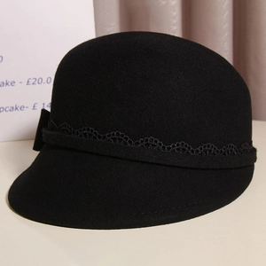 Detail shot of a black wool cloche hat featuring elegant lace trim and a delicate bow knot