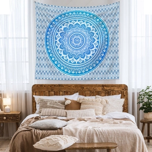 Blue and white mandala tapestry hanging above a bed in a cozy bohemian bedroom decor