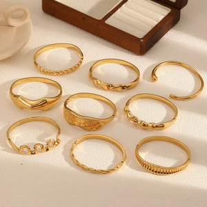 Set of nine assorted gold-plated stainless steel bangles with textured and wavy designs