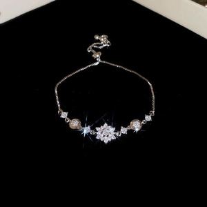 Detail of silver flower bracelet with sparkling zircons on black velvet background