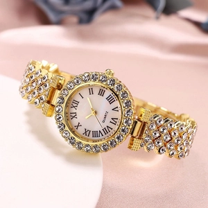 Detailed macro view of a luxury gold watch featuring sparkling rhinestones on a white podium