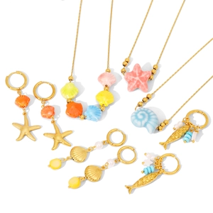 Ocean-themed jewelry set with golden necklaces, ceramic shell pendants and starfish earrings