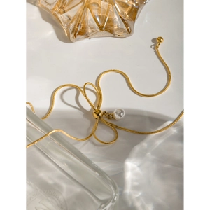 Detail of 18k gold plated stainless steel snake chain with bow and pearl pendant