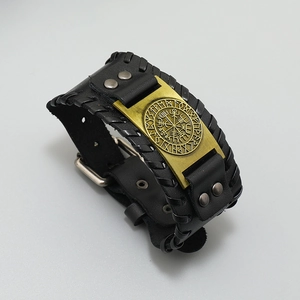 Detail of Viking compass brass plate on men's black braided leather bracelet