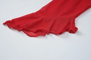 Détail des poignets évasés en résille rouge avec bordure ondulée élégante sur ce haut chic