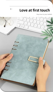 Detailed close-up of A5 light blue leather binder notebook with gold 6-ring mechanism