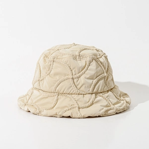 Detail shot of wavy quilted texture on a cream white winter bucket hat for women