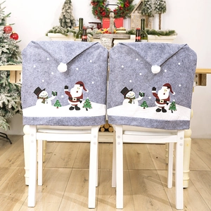 Detail of grey non-woven Christmas chair covers with snowman and santa claus patterns