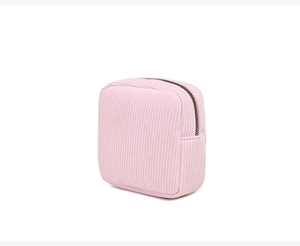Detail of pink corduroy mini cosmetic bag with zipper on a clean white background