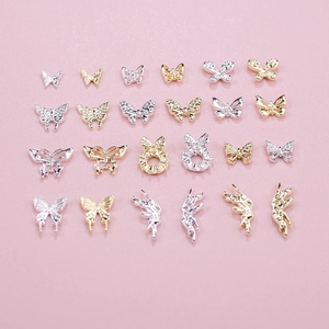 Macro shot of 20 assorted gold and silver butterfly 3D nail art charms in a grid layout