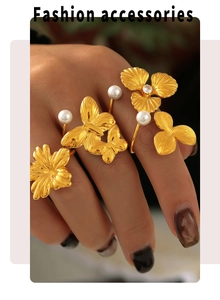 Detail of 18k gold plated stainless steel rings featuring pearl flowers and butterflies