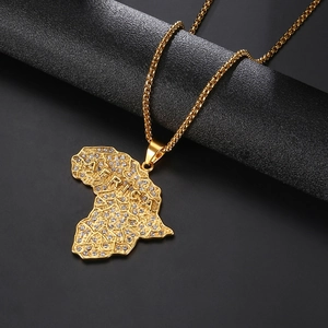 Macro detail of gold African map necklace with crystals and embossed AFRICA text