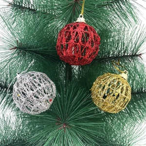 Close-up of glitter hollow Christmas balls in red, gold and silver hanging on a tree branch