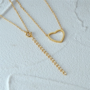 Detail of gold heart pendant necklace showing the adjustable extension chain clasp