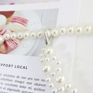 Elegant white pearl waist chain for dresses with silver hook closure on a decorative base