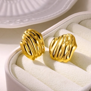 Macro view of gold-plated stainless steel stud earrings with rippled texture and flower petal design