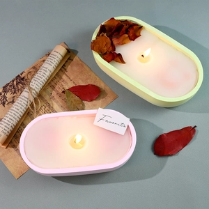 Top view of oval scented candles with dried rose petals in pastel silicone containers
